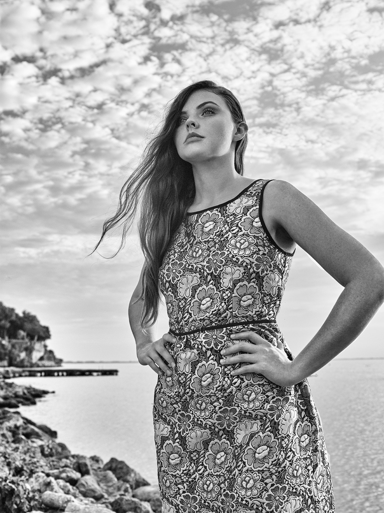 CASTAWAY_Model Elizabeth In Dress Arms Angled Holding Hands On Hips Face Looking Up To Clouds At Catawba Island Country Club Lake In Background