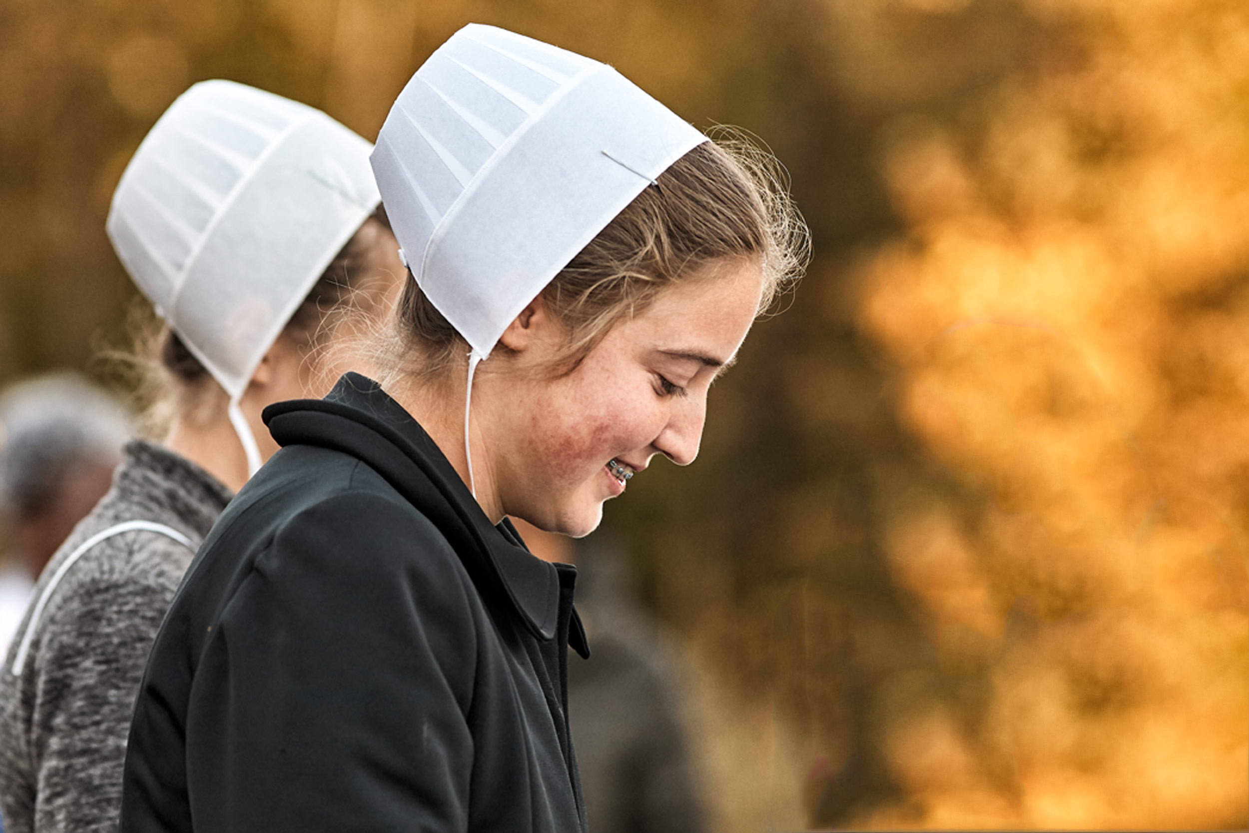 Lifestyle Portrait With West Salem Mission Amish Teen Girls Outside Fall Foliage Using Bokeh To Enhance Scene At Warsaw CMI Revival  