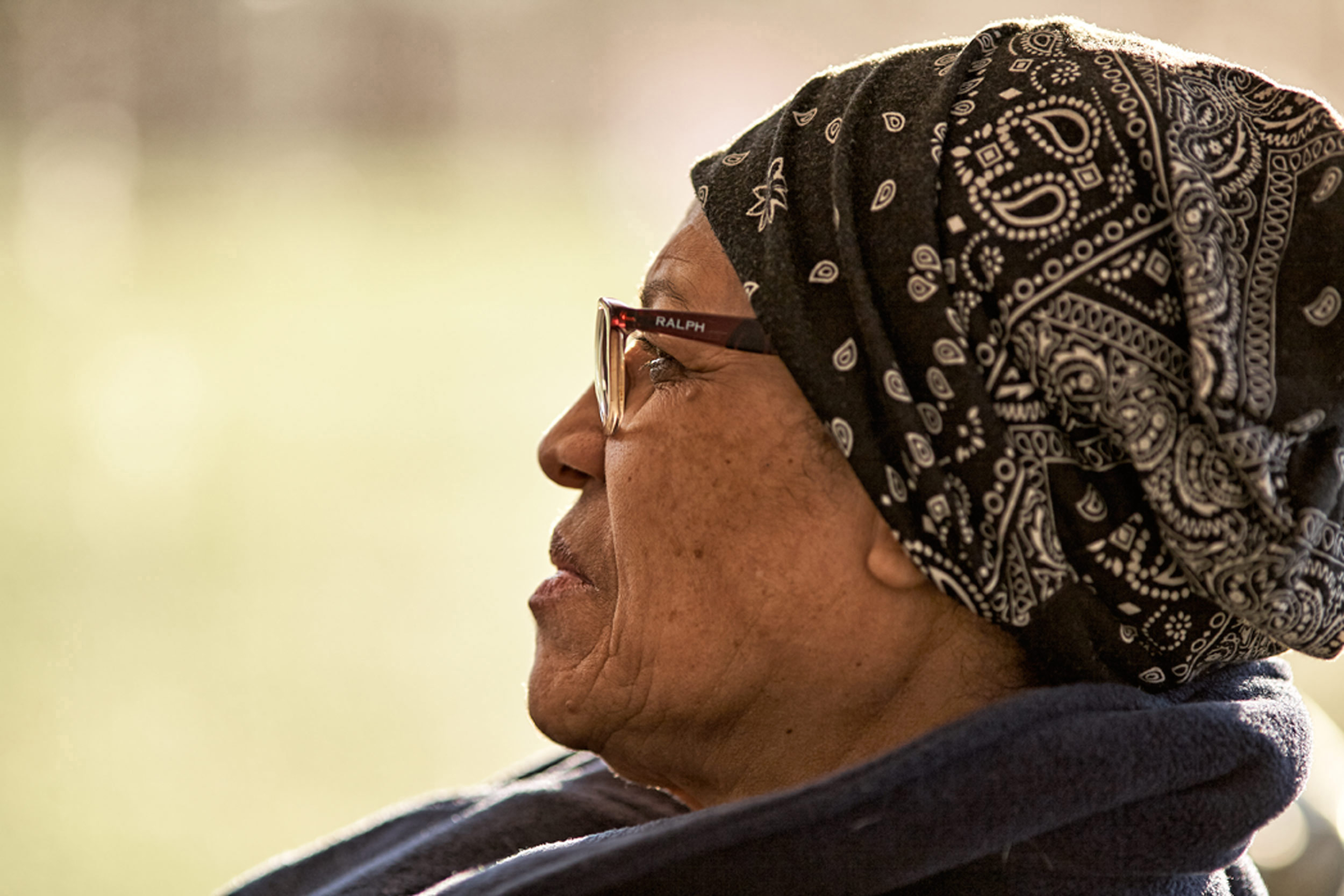 Lifestyle Portrait Using Bokeh To Enhance Scene Of Mature Woman In North Central Ohio Arrayed In Bandanna Focused On Event At Warsaw CMI Revival